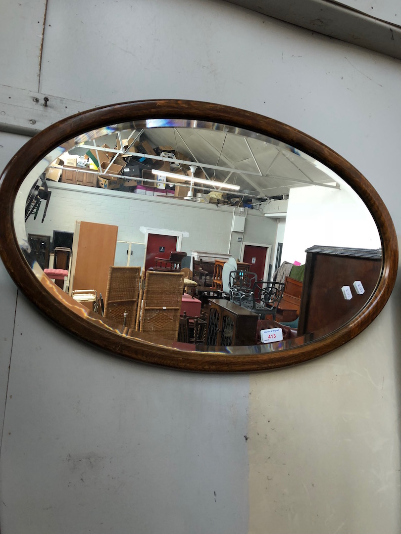 An oval oak framed wall mirror.