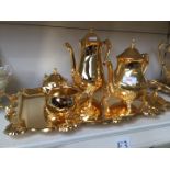 A gold plated tea set comprising tray, tea and coffee pots, milk and sugar.