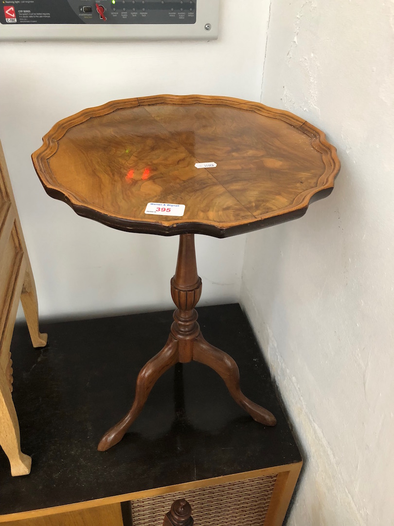 A reproduction figured walnut tripod wine table.