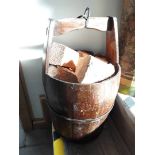 A vintage wood bucket with logs.