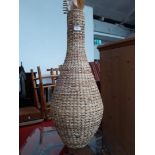 A woven vase with dried flowers, height 80cm.