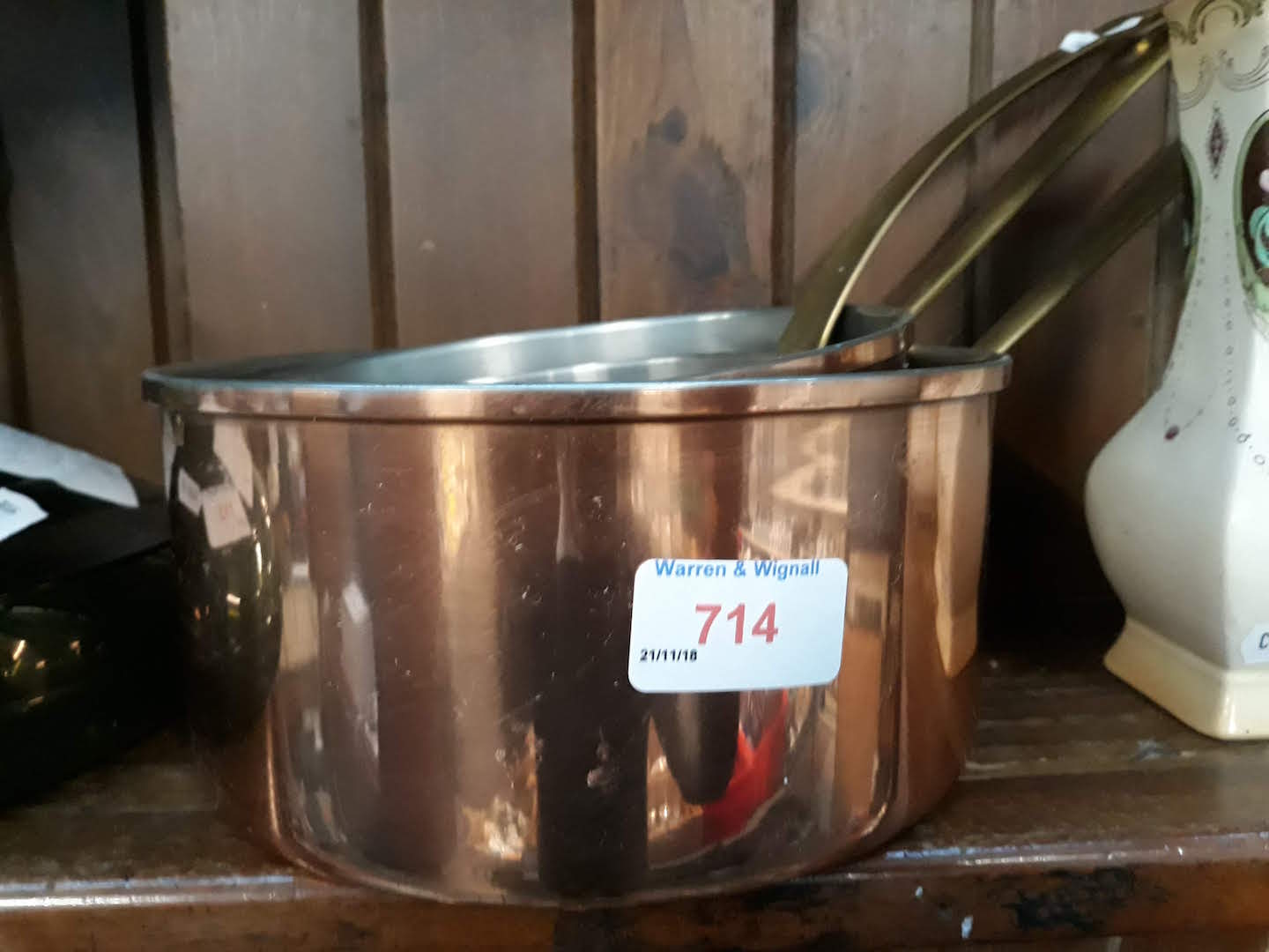A set of three copper and brass pans