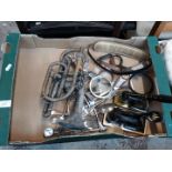 A box of brass and metal items including a cornet, cutlery and two stamps.