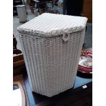 A white Lloyd Loom type bedding basket.