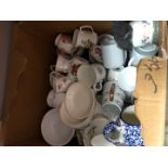 A large box of pottery cups and saucers