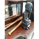 A carved ethnic figurine and two wooden clubs.