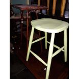 A 2 tier cane table and a green painted stool