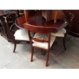 A reproduction mahogany dining table with gadrooned edge and four bar and scroll back chairs