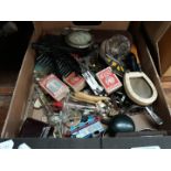 A box of misc items including corkscrews, car badges, etc