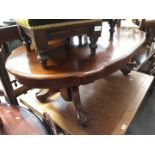 A modern oak oval coffee table with claw and ball feet