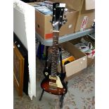 An Encore electric guitar with stand