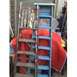 Blue painted wooden step ladders and another set