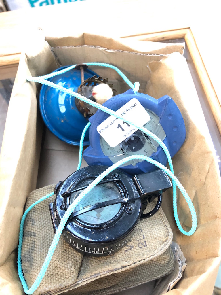A little box containing prismatic compass, a Marine compass and a decorative oil lamp