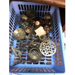 A plastic basket of brassware