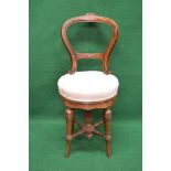 19th century revolving walnut music chair having balloon back and upholstered seat supported on