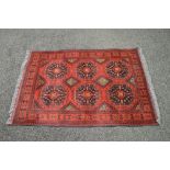 Red ground rug having black and brown pattern with end tassels - 62.