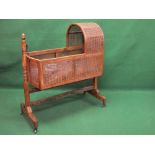 Georgian mahogany childs cradle having cane work arched hood and sides supported on turned uprights,