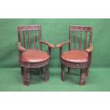 Pair of North African carved wood tribal armchairs with all over studded metal work decoration