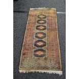 Brown ground rug having black and rust coloured decoration with end tassels - 23.5" x 55.