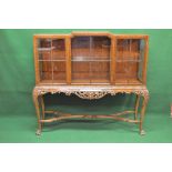 Walnut glazed display cabinet having stepped top and three glazed panelled doors opening to reveal