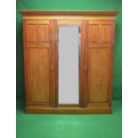 Mahogany three door wardrobe having moulded cornice over mirrored centre door flanked by panelled