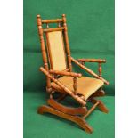 Childs beech frame American style rocking chair on spindle construction having padded back and seat