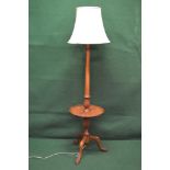 Walnut standard lamp having turned reeded column leading to circular tier with pie crust edge,