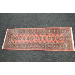 Pink ground carpet runner having black and blue pattern with end tassels - 73" x 26"