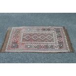 Pink ground rug with brown, blue and green pattern and end tassels - 62" x 33.