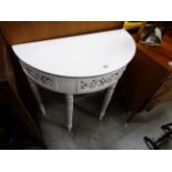 A contemporary white painted demi lune side table with carved frieze panels.