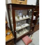 A mahogany Edwardian string inlaid display cabinet raised on four tapering legs.