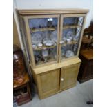 A pine dresser base with glazed two door top raised on a plinth base.