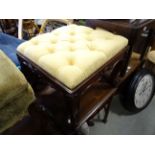 An antique button backed upholstered carved stool raised on cabriole legs with cross carved supports