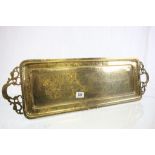 A vintage brass tray with engraved leaf decoration.