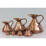 Set of seven graduated Copper measuring jugs with official marks & measurements