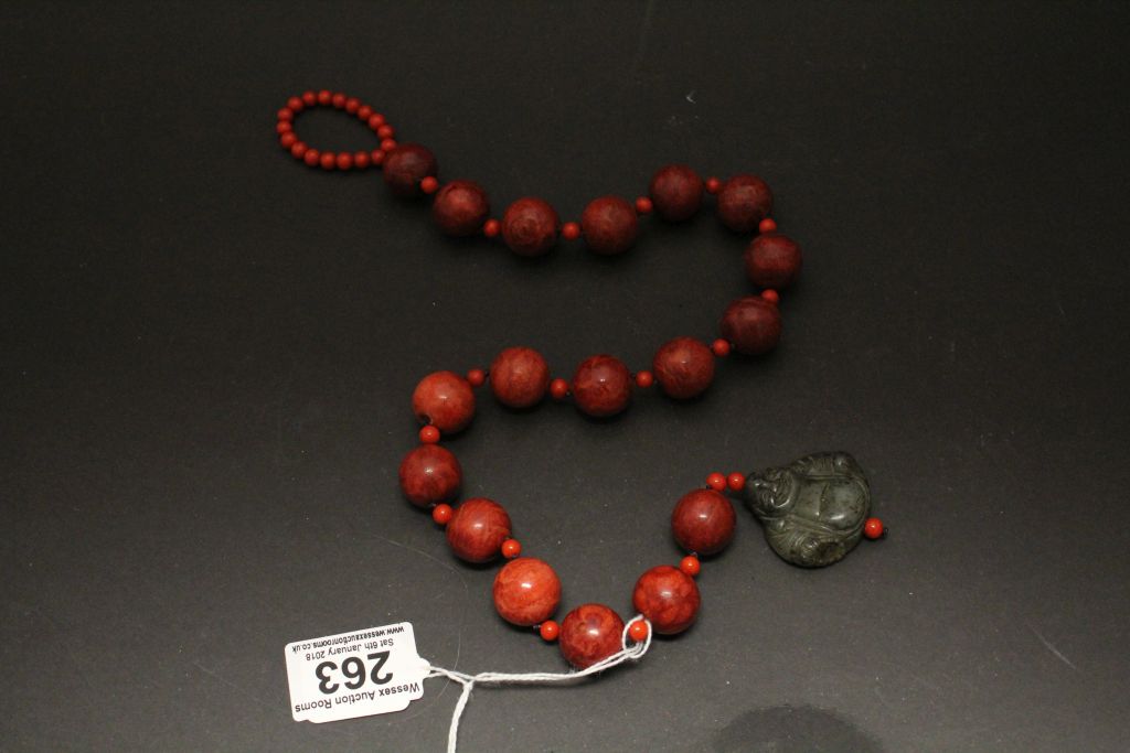 An amber style necklace with Jade crisp in the form of a Buddha