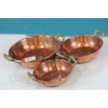 Three Copper Graduating Bowls, each with twin brass handles
