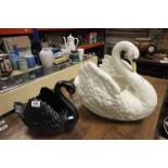 A large antique pottery swan jardiniere unmarked and a similar Dartmouth pottery black swan marked