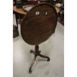 Georgian Mahogany Circular Tilt top table raised on scrolling block feet.