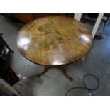 A 19th century elm tilt top tripod table with turned column raised on pad feet.