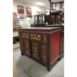 A Chinese lacquered cabinet with carved doors and panels with figures,two drawers over two doors.