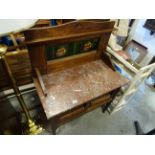 An early 20th century oak marbled topped washstand with shaped tiled back.