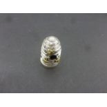 Silver thimble in the shape of a beehive with needle stand