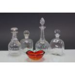 Four glass decanters and an art glass dish.