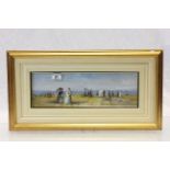 A gilt framed oil painting of a Victorian beach scene, figures with parasols and beach hut