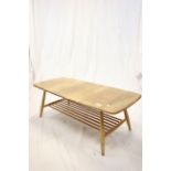 Ercol Pale Elm Top Coffee Table raised on a beech turned legs and slatted book shelf