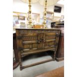 Mid 20th century Oak Jacobean Style Side Cabinet with two carved panel doors raised on turned legs