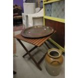 A folding occasional table a persian brass plate and a stoneware jar.