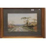 A gilt framed landscape watercolour with farm and cottage beside a country track with signature