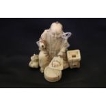 A meiji period carved ivory okimono of a seated man cooking.